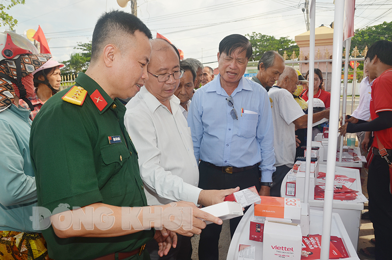 Lãnh đạo huyện Bình Đại xem điện thoại giảm giá hỗ trợ người dân chuyển máy 2G lên 4G.