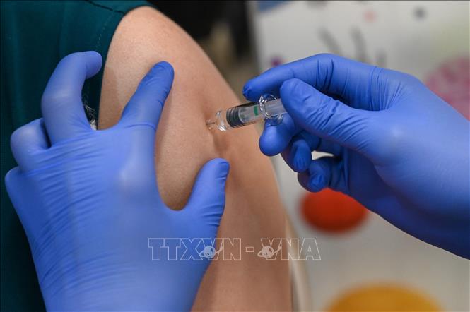 Singapore đối mặt với làn sóng COVID-19 mới Tiêm vaccine ngừa COVID-19 tại Singapore. Ảnh tư liệu: AFP/TTXVN