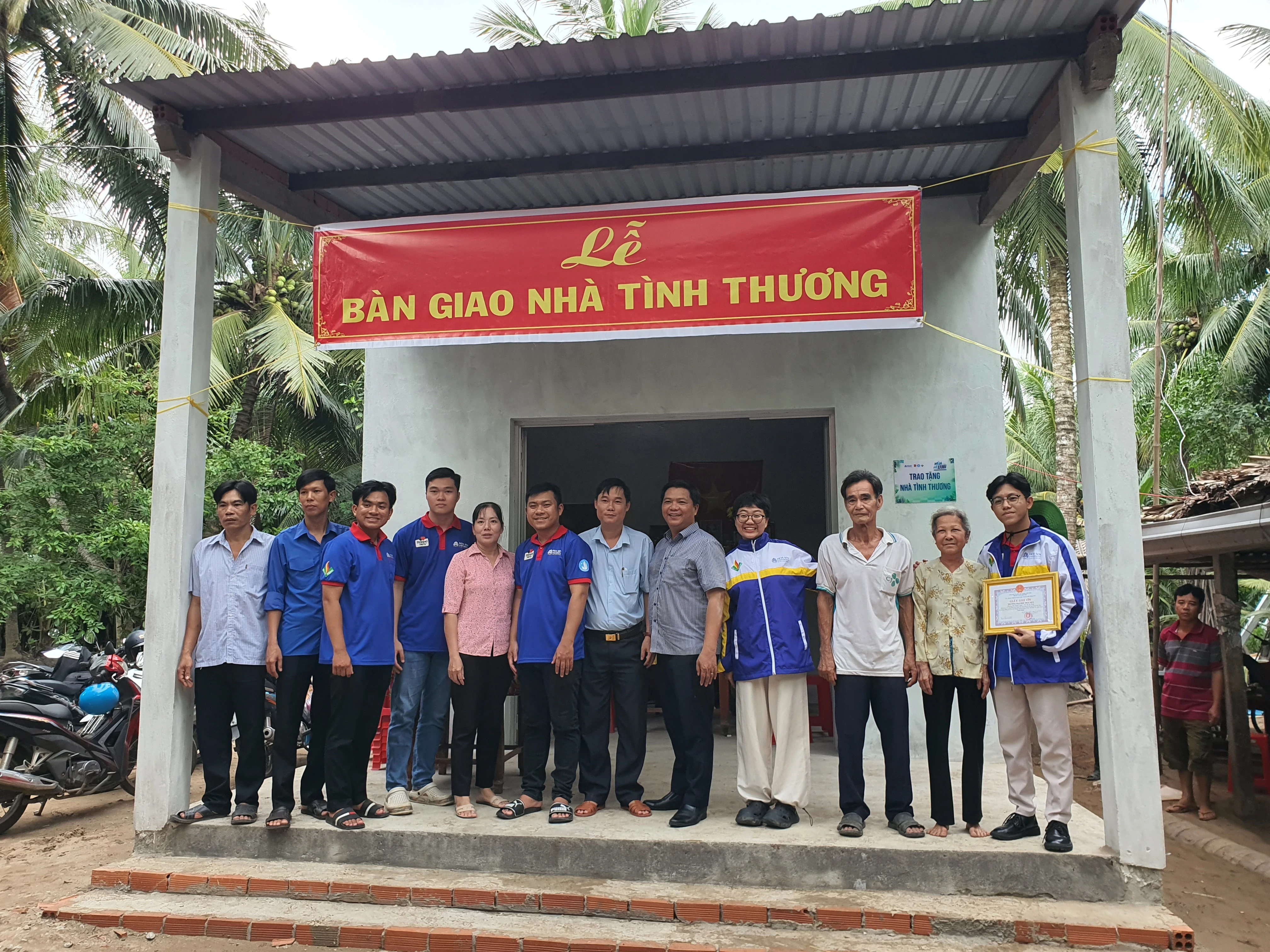 Bạn Huỳnh Gia Điềm (thứ 4, từ phải sang) tại lễ bàn giao nhà tình thương tại mặt trận xã Tân Lợi Thạnh, huyện Giồng Trôm năm 2024.