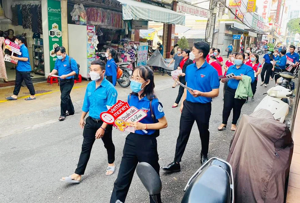 Đoàn viên, thanh niên ra quân hướng dẫn người dân tiếp cận chương trình thanh toán không dùng tiền mặt.