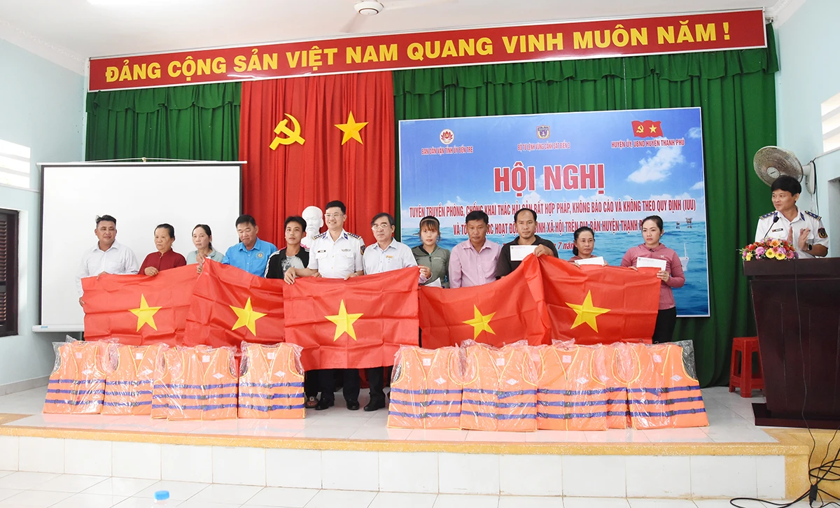 Đại tá Cao Xuân Quận - Phó chính ủy Bộ Tư lệnh Vùng Cảnh sát biển 3 (thứ 6, trái sang) gặp gỡ, trao cờ Tổ quốc và tuyên truyền phòng, chống khai thác hải sản bất hợp pháp, tại Đồn Biên phòng Cổ Chiên. Ảnh: Cẩm Trúc