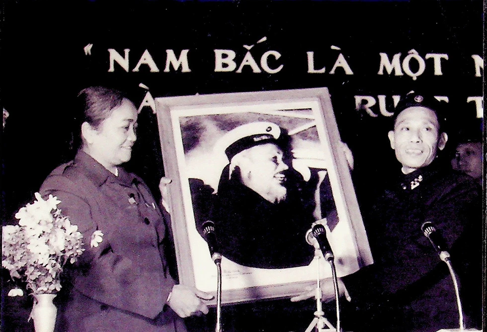 Hội trưởng Hội Liên hiệp Phụ nữ Việt Nam Nguyễn Thị Định đại diện đoàn phụ nữ miền Nam nhận ảnh Bác do đồng chí Phạm Văn Đồng trao tặng. Ảnh: tư liệu
